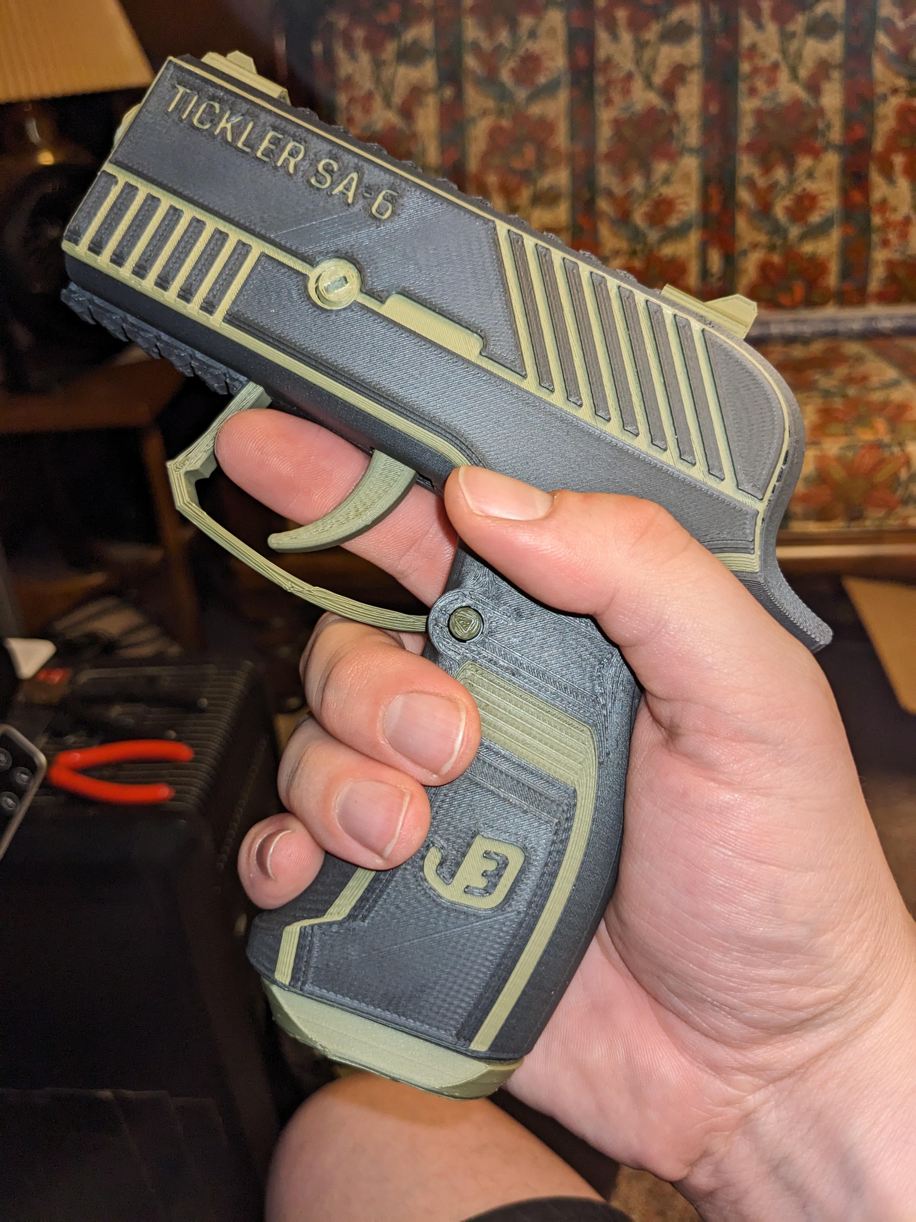 Tickler SA-6 — Fully 3D-printable semi-automatic airsoft pistol - Turned out pretty ok! I had to print most of the smaller parts on a raft to get them to stick, resulting in some ugly faces, but you can't really tell unless you're looking super close. The clip release button/lock broke after 1 use and it's holding better with super glue lol. The housing rear nut sheared itself apart while screwing it in so I'm reprinting it with 50%infill. The housing I think got warped because I took the left one off the bed while it was still hot. So I might do another make with a new color scheme. Maybe red highlights so I don't get shot if I ever take it out in public 😭

Haven't tried loading it yet but it's on my to do list. The trigger and clip move smoothly enough on their rubber bands. I think it will work well enough. Although the trigger had some trouble seizing up at first until I grinded out some imperceptible support gunk. Overall a good model. Thanks! - 3d model