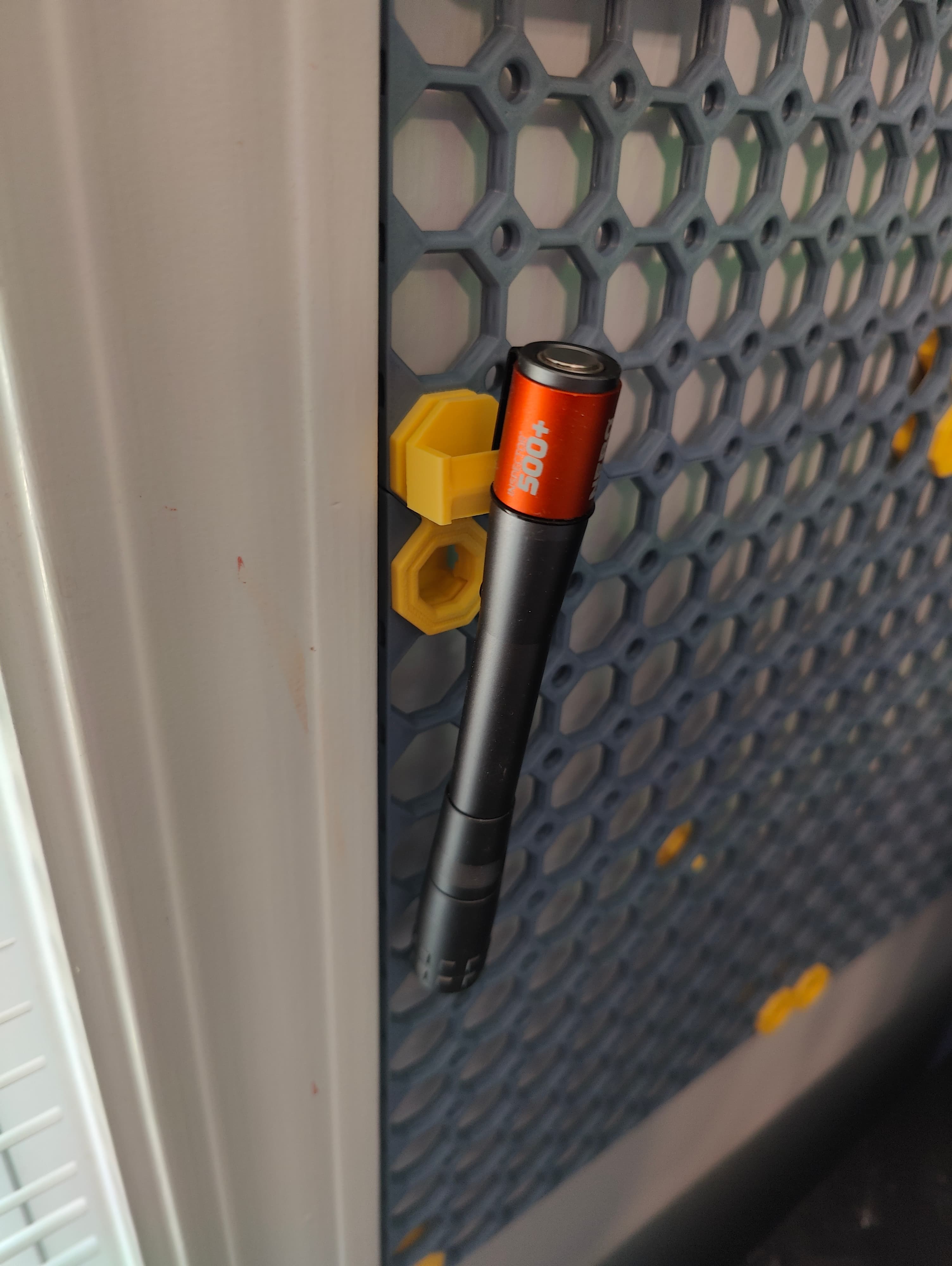 Printed one to hold the small flashlight I keep near the printer to help finding small bits that fall off/behind the desk. Holds firm, but it's easy to slide up and off.