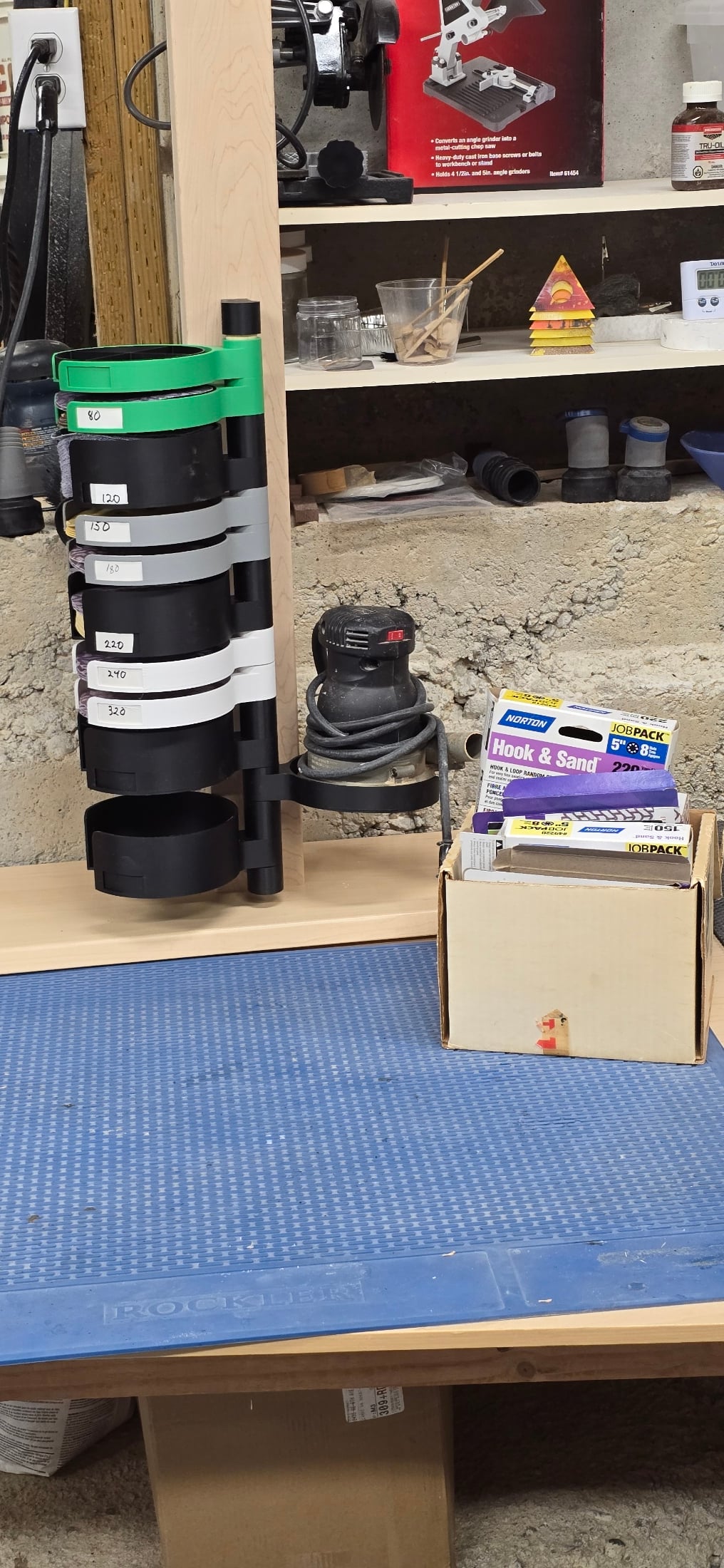 Very nice improvement to my sandpaper storage. Mounted to a mobile base so it can be moved to the sanding location. It also works as a platform for a 5" random orbital sander. It would be nice to have a slightly beefier base for the sander.