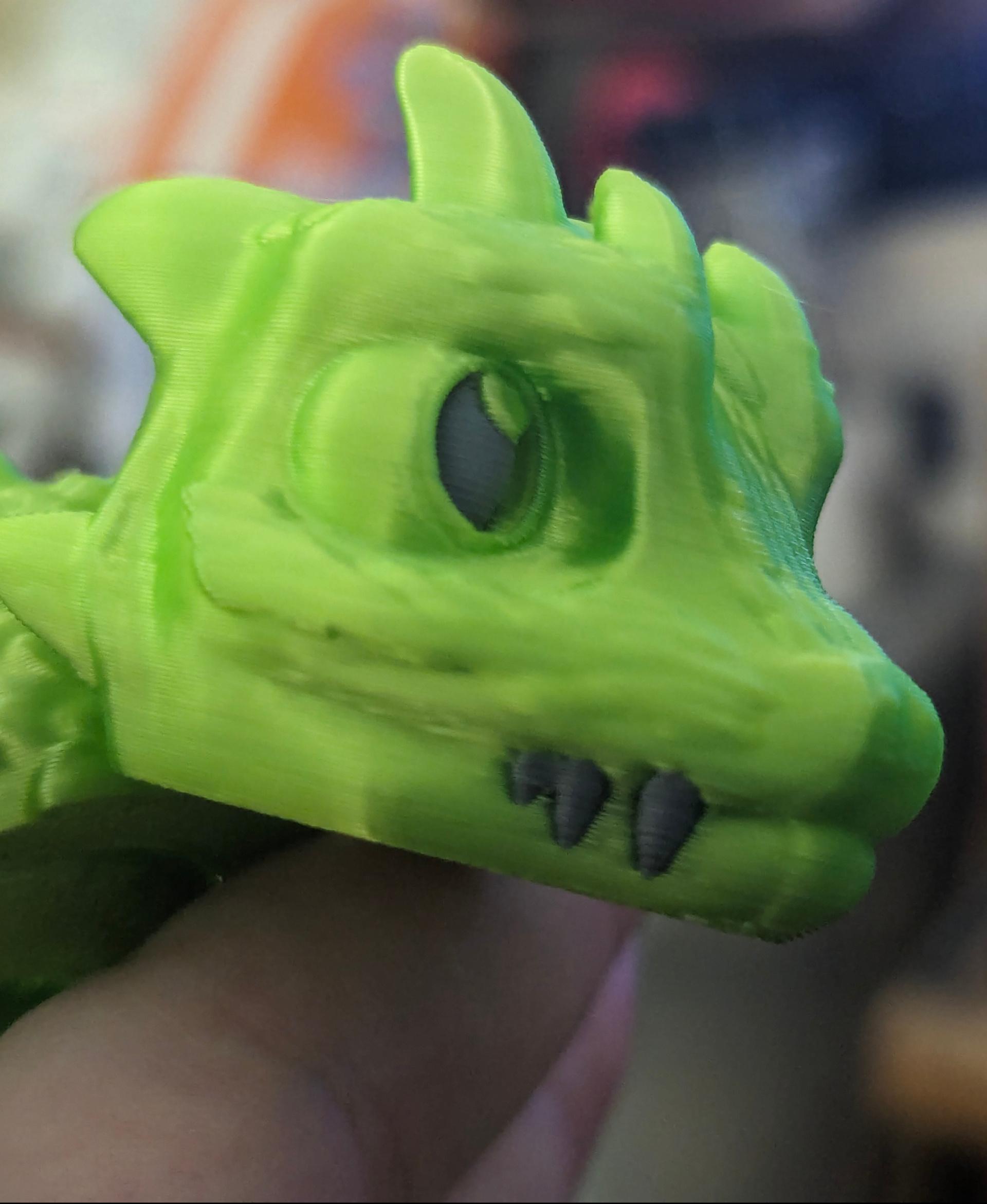 Baby Basilisk (Extra Long) - Articulated Snap-Flex Fidget (Medium Tightness Joints) - Printed on a Bambu Lab P1S, with Duramic 3D Silk PLA in neon green. Eyes and teeth are Duramic 3D PLA in smoke gray. - 3d model