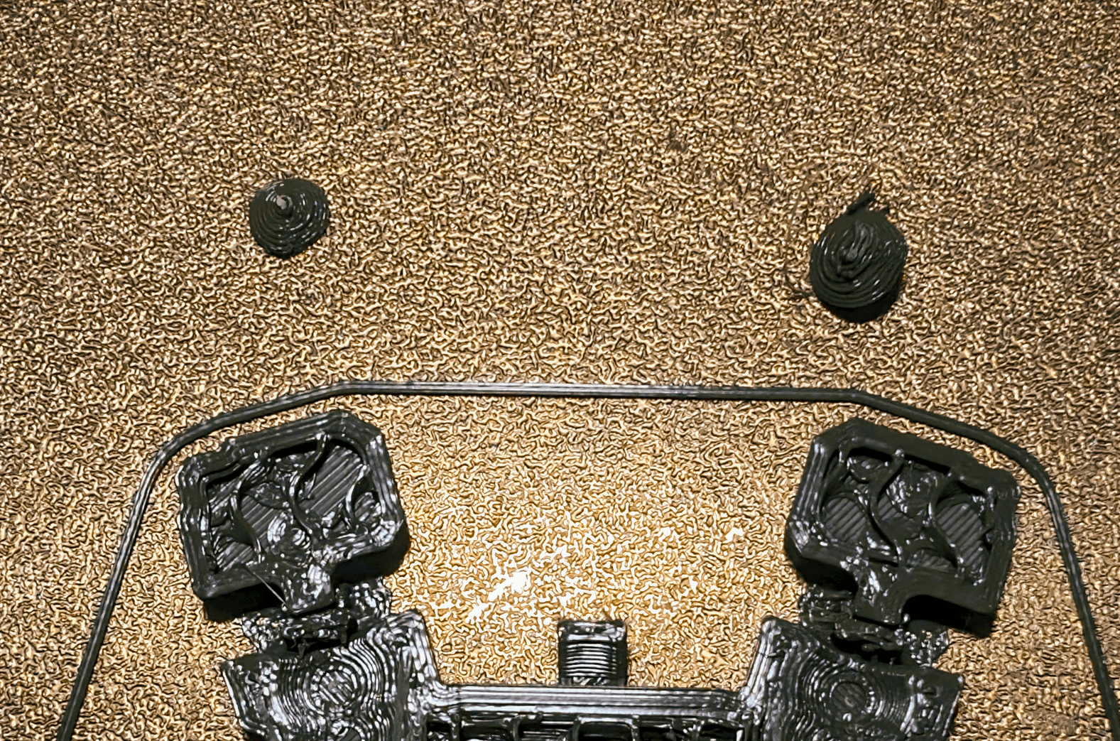 I tried to print twice and both failed. The first was my fault, I was pushing my luck with my quality settings, no glue, and zero supports. The second print was coming along great until the bottom part of the shoulder joint (the ball) popped out of the socket mid print. Any ideas how to mitigate that happening again?
I took a closer look. The ball on the left was very clean and round. Came to a crisp point touching the base. The ball on the right was very sloppy and there were some stray strands underneath it. I think it failed almost immediately, probably because the point touching the base is so small.
Perhaps making the ball a little flatter would help?