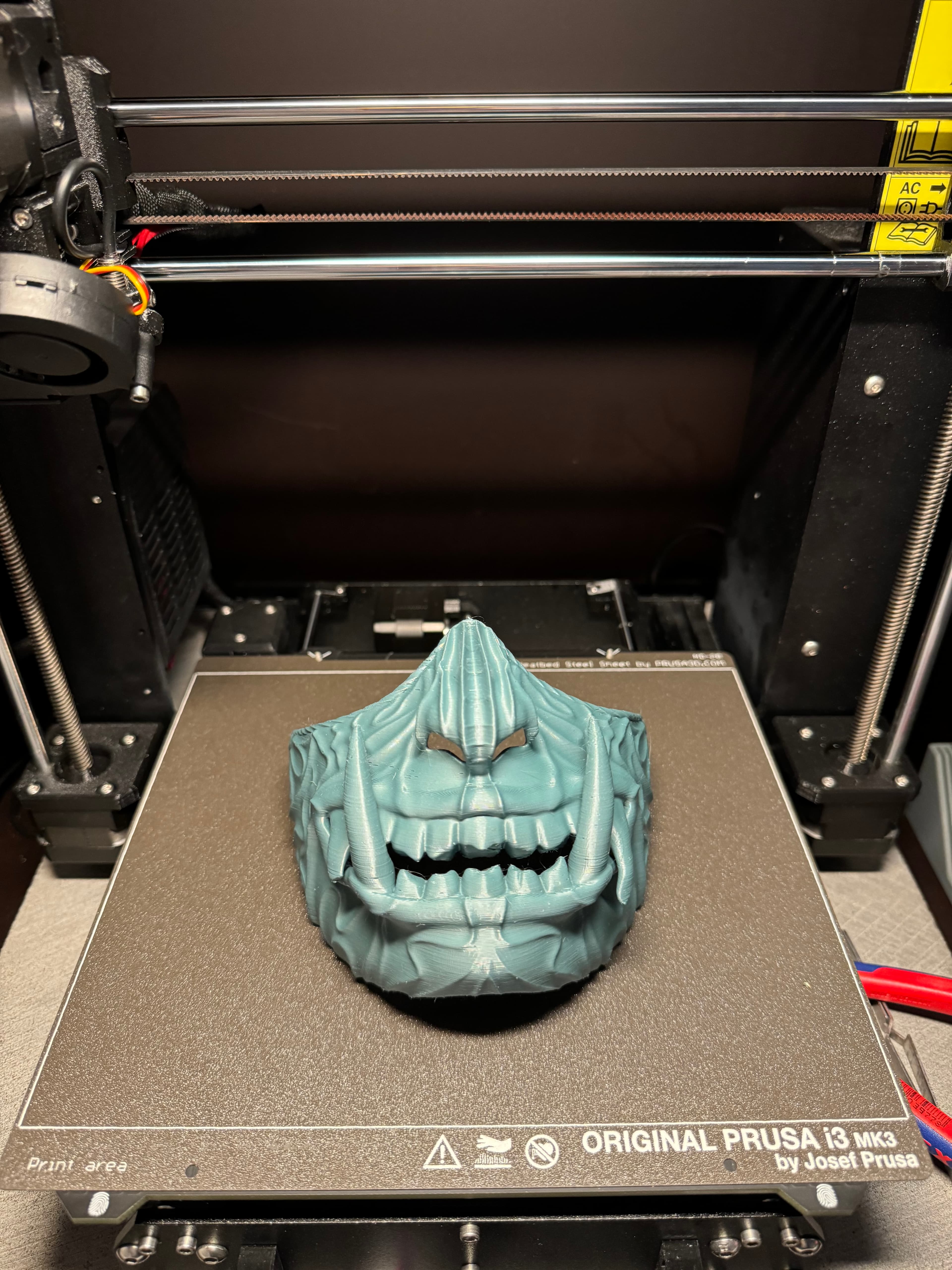 Did a scaled down version for my 5y/o son. Scaled to 87%, I measured his cheekbones left to right and scaled it manually on prusa slicer on the measuring net of the sheet. Was really easy. Settings on 0.2mm and 15% infill with organic supports. Removing supports on the inner teeth was a bit hard, but okay. Sanded the outline so he cannot hurt himself while playing.
Now he is playing ninja with Oni mask like in Ninjago.