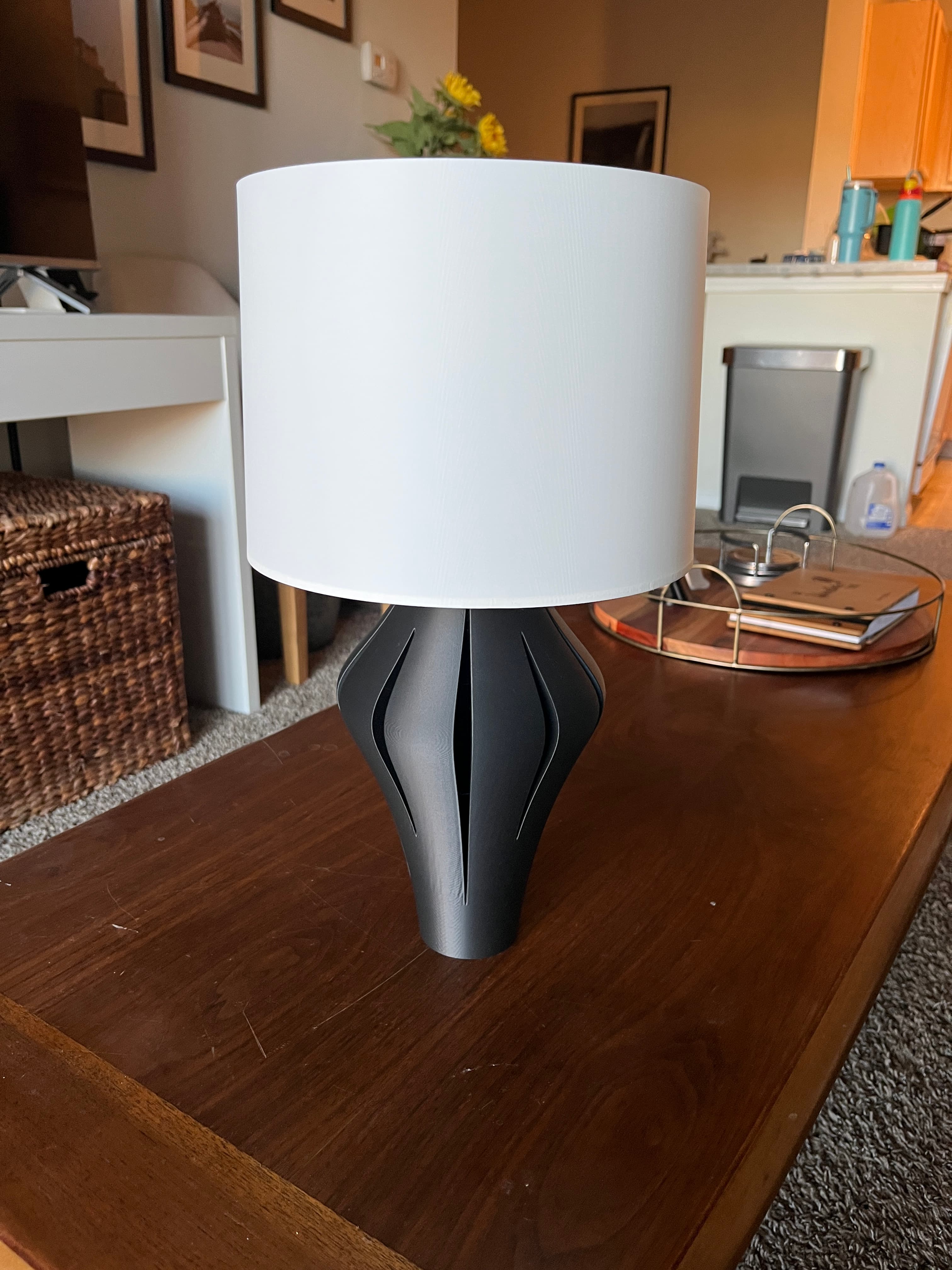 Printed in Overture Matte Black/White.
Base placed upside down on the print bed to avoid supports, and I printed the shade in vase mode with a 0.6mm line width to diffuse the light more.
Base was 5% infill with 2 walls, but I added a modifier to the area that will be on the table to make it bottom-heavy with 30% infill.
I use Aliexpress cords for all of my lamps and they unfortunately do not have a section that helps to lock against the lip. I modified an E27 collar from Printables to act as a collar to secure the light bulb. I then just used a soft white LED bulb