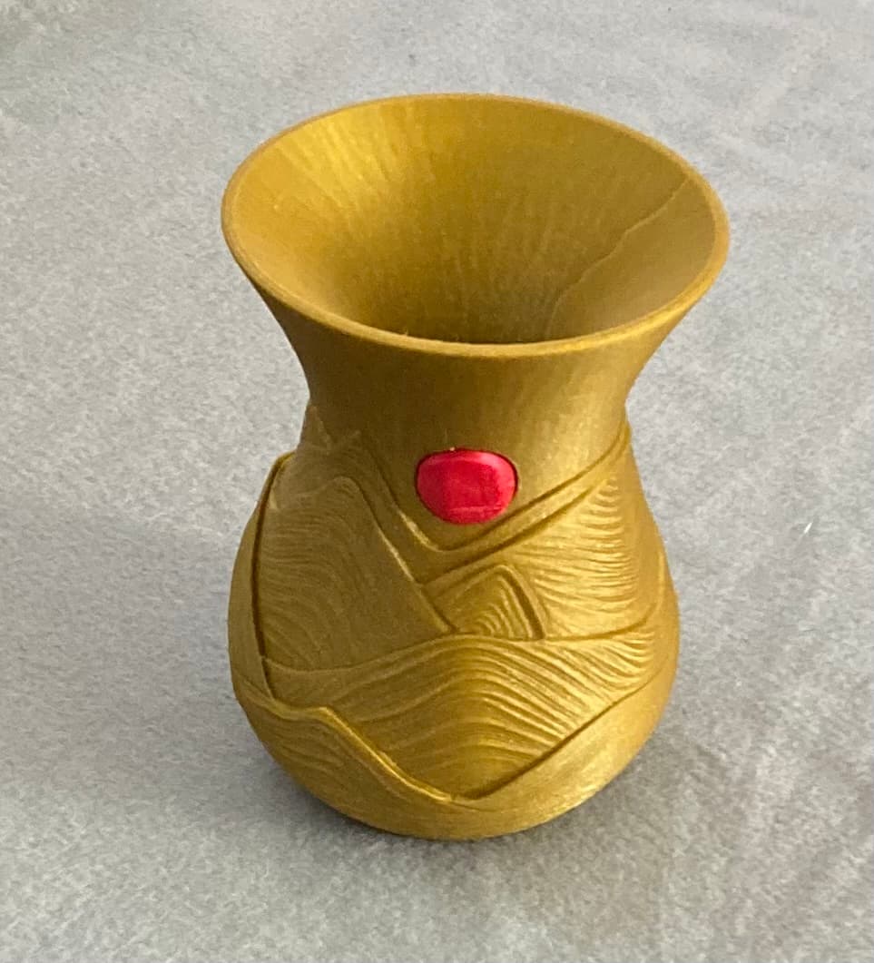 As distributed, the suns are larger than the sockets they should fit into. Using the I.D. of the recess (21mm) and the O.D. of the original suns (29mm), printing the suns at a scale of 21/29 or 72% gives a sun which snaps right into place as shown here. Filaments were Printed Solid Jessie Golden Winner PLA and Sunlu Matte Red PLA.